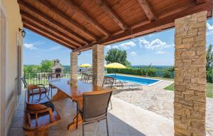 um pátio com uma mesa e cadeiras e uma piscina em Nice Home In Bregi With Outdoor Swimming Pool em Katun Gračanski