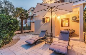patio z 2 krzesłami i parasolem w obiekcie Holiday Home Medulin Ii w Medulinie +37 zdjęć