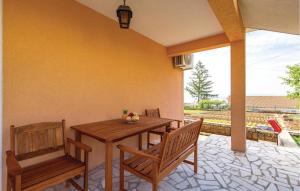 a wooden table and two benches on a patio at 2 Bedroom Cozy Apartment In Rubesi in Rubeši