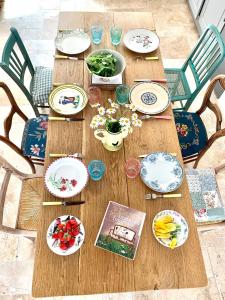 una mesa de madera con platos y cuencos de comida. en Maison Léontine, en Bernay