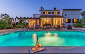 a swimming pool in front of a house at Lovely Home In Loborika in Loborika