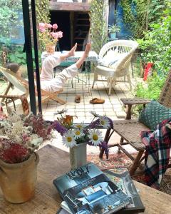 un patio con mesa, sillas y flores en Maison Léontine, en Bernay