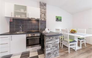 a kitchen with white cabinets and a sink and a table at Stunning Apartment In Pavicini With Wifi in Pavicini