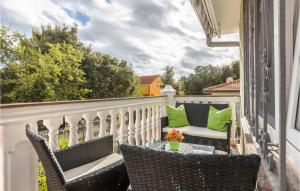 a balcony with two chairs and a table with green pillows at Lovely Apartment In Pavicini With Wifi in Pavicini