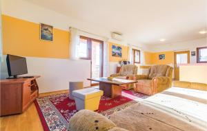 een woonkamer met een bank en een tv bij Lovely Home In Krnica With House Sea View in Krnica