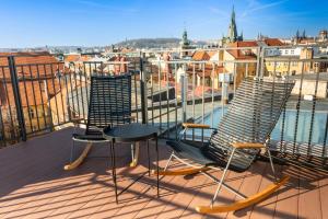 3 chaises et une table sur un balcon avec vue dans l'établissement Miss Sophie's Downtown, à Prague