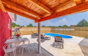 a patio with a table and chairs and a pool at One-Bedroom Holiday Home In Hreljici in Hreljići