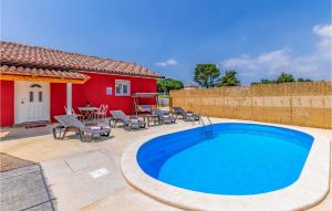 a swimming pool in a yard with a red house at One-Bedroom Holiday Home In Hreljici in Hreljići