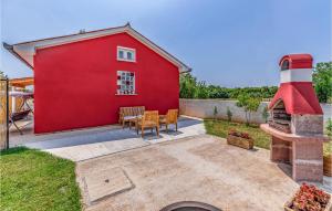 a red barn with a table and chairs and a fireplace at One-Bedroom Holiday Home In Hreljici in Hreljići +17 photos