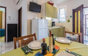 kuchnia ze stołem, krzesłami i lodówką w obiekcie Amazing Apartment In Novigrad With Wifi w mieście Novigrad