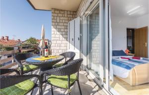 balkon ze stołem, krzesłami i łóżkiem w obiekcie Amazing Apartment In Novigrad With Wifi w mieście Novigrad +11 zdjęć