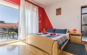 sypialnia z łóżkiem z czerwoną ścianą w obiekcie Amazing Apartment In Novigrad With Wifi w mieście Novigrad