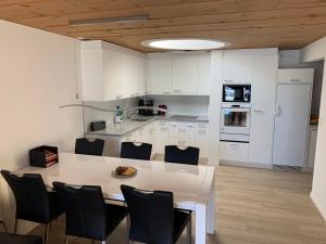 a kitchen with a large white table and chairs at Touring 401 in Davos