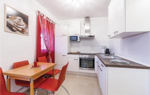 a kitchen with a wooden table and red chairs at Beautiful Apartment In Fondole With Kitchen in Fondole