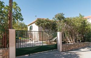 a gate in front of a house with trees at Holiday Home Supetar 98 With Game Room in Supetar