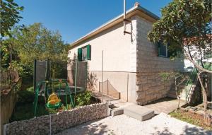a house with a playground in a yard at Holiday Home Supetar 98 With Game Room in Supetar