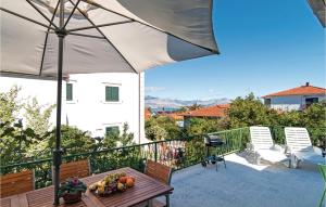 a patio with a table with fruit and an umbrella at Holiday Home Supetar 98 With Game Room in Supetar