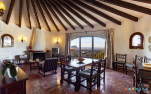 a dining room with a table and chairs and a fireplace at VH CostaBlanca - RULLE in Benissa
