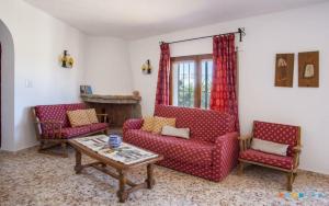 uma sala de estar com duas cadeiras vermelhas e uma mesa em VH CostaBlanca - RULLE em Benissa