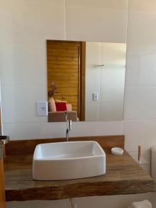 a bathroom with a white sink and a mirror at Pousada Portal da Praia in Anchieta