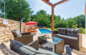 a patio with chairs and an umbrella and a pool at Nice Home In Krsan With Kitchen in Kršan