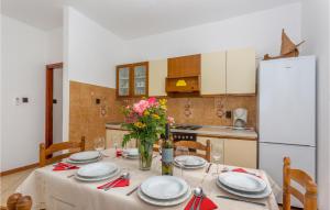 una cocina con una mesa con platos y flores. en 2 Bedroom Awesome Apartment In Omisalj, en Omišalj