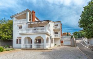 Casa blanca con balcón y entrada en 2 Bedroom Awesome Apartment In Omisalj, en Omišalj