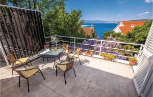 patio ze stołem i krzesłami na balkonie w obiekcie 2 Bedroom Beautiful Home In Kraljevica w mieście Kraljevica
