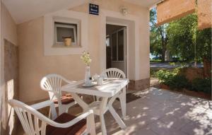 einen weißen Tisch und Stühle auf einer Terrasse in der Unterkunft Nice Apartment In Raslina With House Sea View in Raslina