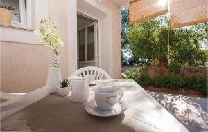 einen Tisch mit einer Kaffeetasse und eine Vase mit Blumen in der Unterkunft Apartment Raslina Lxvii in Raslina