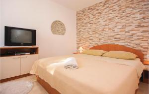 ein Schlafzimmer mit einem Bett und einem TV an einer Backsteinwand in der Unterkunft Apartment Raslina Lxvii in Raslina