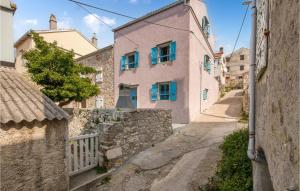 an alley in a village with pink houses at Stunning Home In Unije With Wifi in Unije
