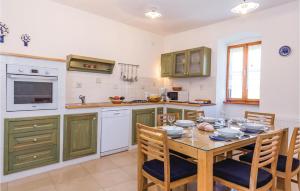 a kitchen with a wooden table with chairs and a tableasteryasteryasteryasteryastery at Awesome Home In Martina With House Sea View in Martina