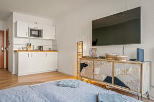 1 dormitorio con TV de pantalla plana grande en la pared en CASSEL LOFTS - Stylisches Dschungel-Studio nähe Uni & Klinikum, en Kassel