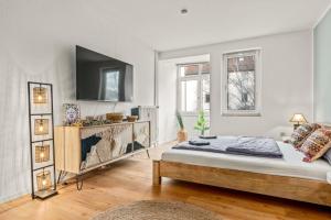 Un dormitorio con una cama y un televisor en una pared. en CASSEL LOFTS - Stylisches Dschungel-Studio nähe Uni & Klinikum, en Kassel