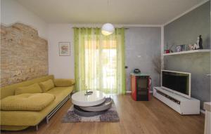 - un salon avec un canapé et une télévision dans l'établissement Beautiful Home In Rovinj With 2 Bedrooms, Wifi And Outdoor Swimming Pool, à Rovinj