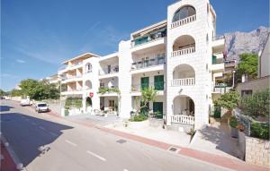 un edificio blanco al lado de una calle en Cozy Apartment In Makarska With Kitchen en Makarska