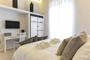 sypialnia z białym łóżkiem i telewizorem w obiekcie Luxury Home Vittoria w Rzymie