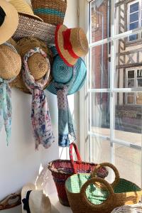 a group of baskets hanging on a wall next to a window at Maison Léontine in Bernay