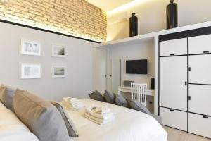 sypialnia z białym łóżkiem i telewizorem w obiekcie Luxury Home Vittoria w Rzymie