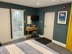 a bedroom with a desk and a bathroom with a shower at Dairy Guest House in York