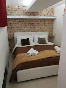 um quarto com uma cama grande e uma parede de tijolos em BAARIA House Hotel em Barcellona Pozzo di Gotto