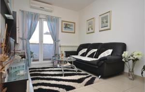 a living room with a black leather couch and a window at Lovely Apartment In Supetar With Wifi in Supetar