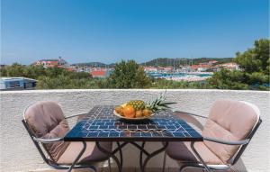 a table and two chairs with a bowl of fruit on it at One-Bedroom Apartment In Jezera in Jezera