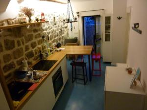 a kitchen with a counter and a table in it at Apartment Old Town Design in Rab