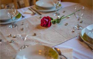 a table with wine glasses and a rose on it at 2 Bedroom Gorgeous Apartment In Njivice in Njivice