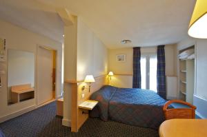 Cama ou camas em um quarto em Hotel Le Bourbon Pau Centre
