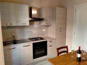 a kitchen with wooden cabinets and a table with wine glasses at Casa Toscanella in Pescia