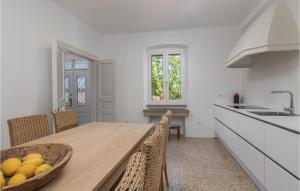 a kitchen with a table with a bowl of fruit on it at Awesome Home In Labin With Kitchen in Labin
