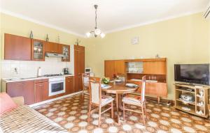 Lovely Apartment In Pula With Wifi في Loborika: مطبخ مع طاولة وغرفة طعام